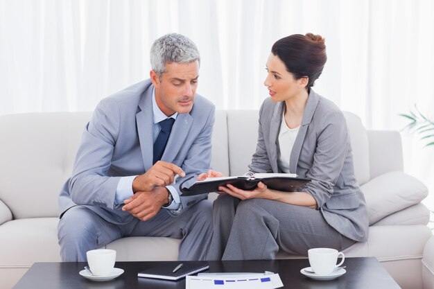 Empresarios serios trabajando y hablando juntos en el sofá