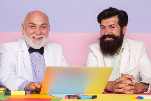 Empresarios sonrientes con una computadora portátil trabajando en el lugar de trabajo