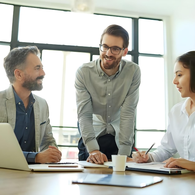 Empresarios sonrientes teniendo una discusión mientras colaboran en un nuevo proyecto en una oficina