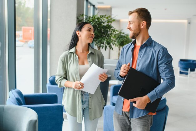 Los empresarios sonrientes trabajan colaborando en la lluvia de ideas de la computadora sobre el inicio de la empresa en la reunión de la oficina Diversos colegas motivados miran la pantalla de la computadora portátil y discuten ideas de proyectos de negocios juntos