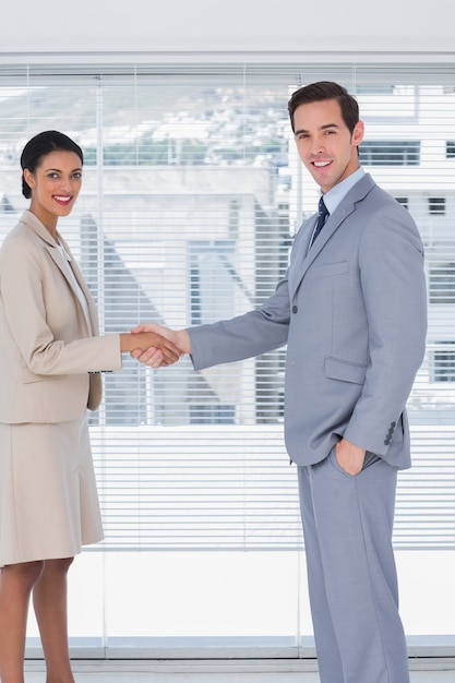 Empresários sorridentes apertando as mãos