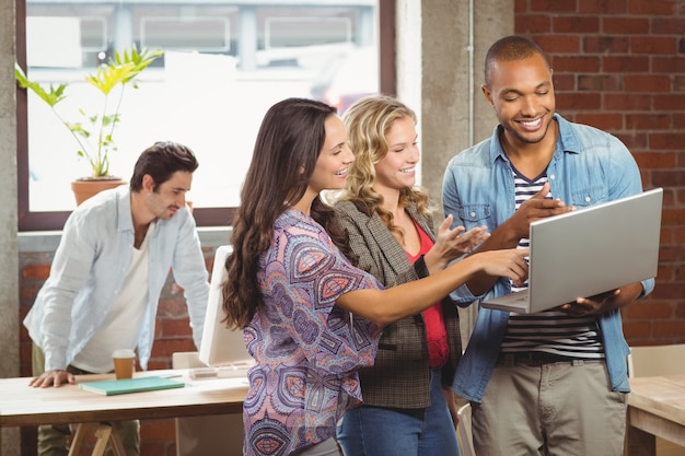 Empresários sorridentes apontando para o laptop