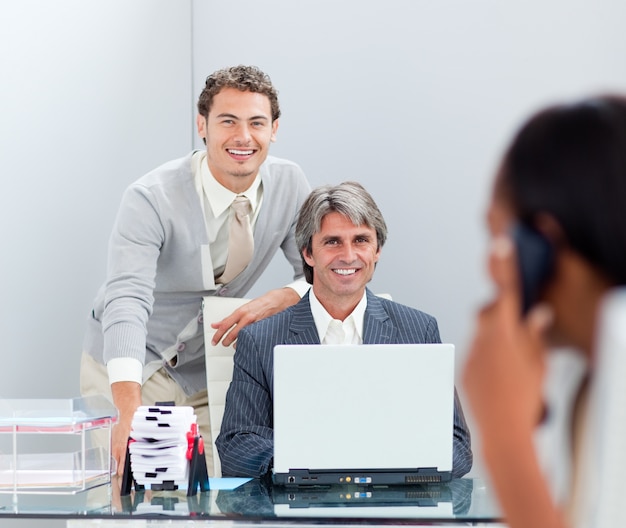 Empresários sorridentes trabalhando em um computador juntos