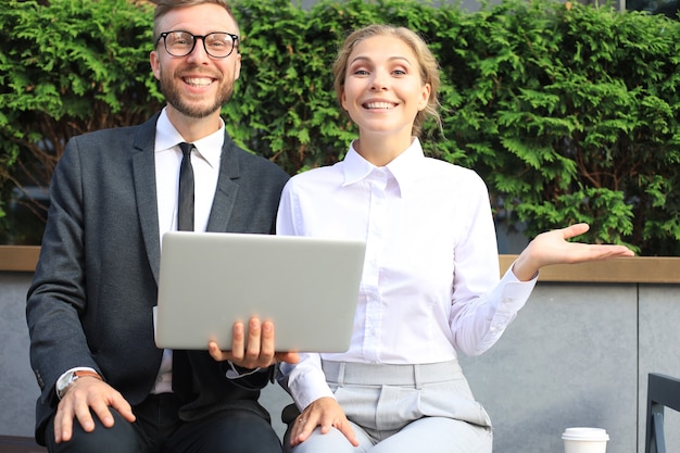 Empresários surpresos com informações do laptop.