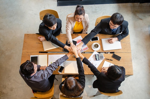 Foto los empresarios trabajan juntos para demostrar relaciones de construcción de unidad para la vista superior del trabajo en equipo