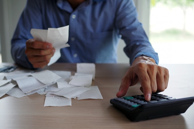 Foto empresários usam a calculadora para calcular a conta colocada na mesa. conceito de dívida