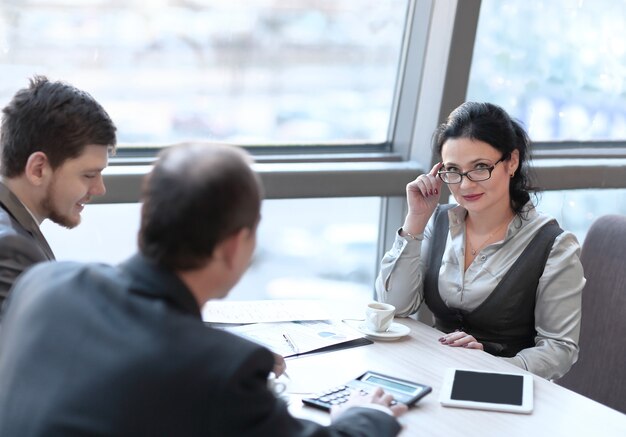 Los empresarios usan la calculadora para discutir los gráficos de los análisis.