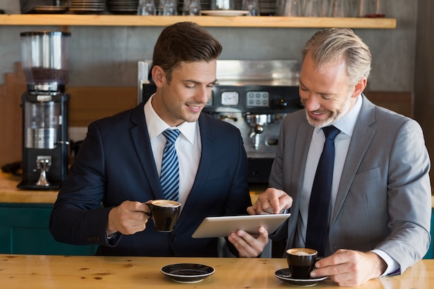 Empresários usando tablet digital no café