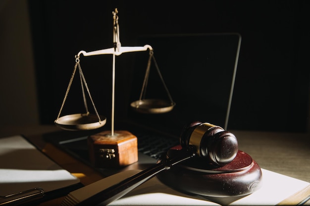 Empresas y abogados discutiendo documentos contractuales con una balanza de bronce en el escritorio de la oficina Servicios legales de asesoramiento jurídico Justicia y concepto de ley Imagen con efecto de grano de película