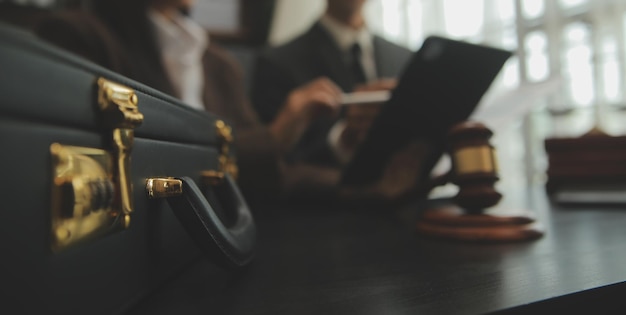 Foto empresas y abogados discutiendo documentos contractuales con una balanza de bronce en el escritorio de la oficina servicios legales de asesoramiento jurídico justicia y concepto de ley imagen con efecto de grano de película