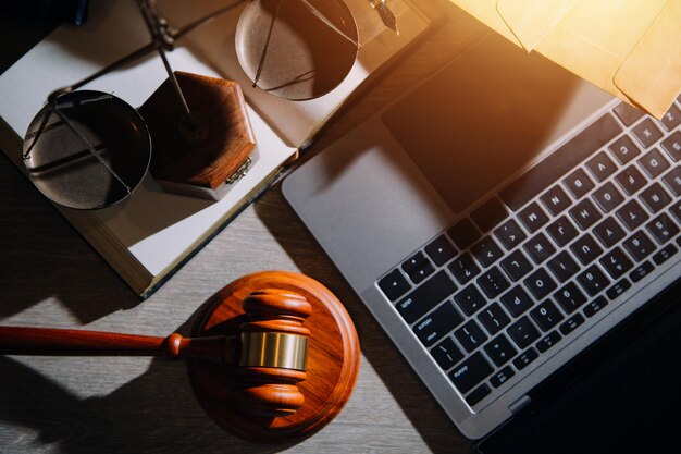 Foto empresas y abogados discutiendo documentos contractuales con una balanza de bronce en el escritorio de la oficina servicios legales de asesoramiento jurídico justicia y concepto de ley imagen con efecto de grano de película