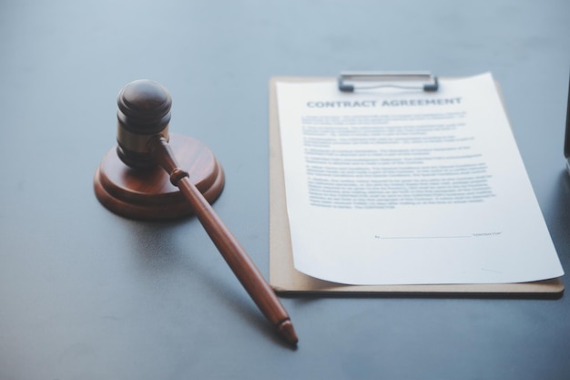 Empresas y abogados discutiendo documentos contractuales con una balanza de bronce en el escritorio de la oficina Servicios legales de asesoramiento jurídico Justicia y concepto de ley Imagen con efecto de grano de película