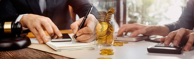 Empresas y abogados discutiendo documentos contractuales con una balanza de bronce en el escritorio de la oficina Servicios legales de asesoramiento jurídico Justicia y concepto de ley Imagen con efecto de grano de película