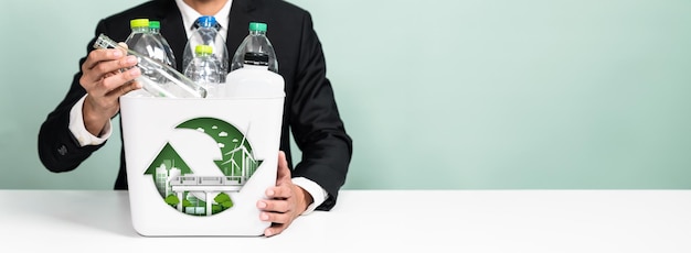 Empresas ecológicas con compromiso ESG para hacer una campaña más ecológica con el reciclaje corporativo y la gestión de residuos Empresario sostiene el contenedor de reciclaje promoviendo un entorno limpio sosteniblePanorama Reliance.