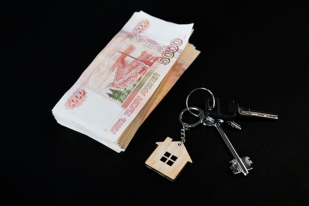Empréstimo bancário hipotecário para a compra de aluguel de financiamento imobiliário e novo pacote de dinheiro para o conceito de casa Notas russas mil rublos e chaves de casa