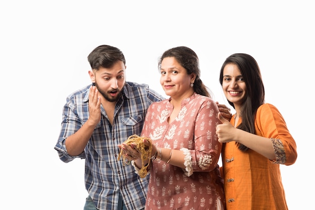 Empréstimo de ouro ou conceito de hipoteca - mãe indiana com filho e filha segurando joias de ouro