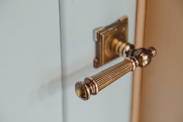 Empuñadura de puerta de bronce en un estilo clásico en una puerta interior de madera