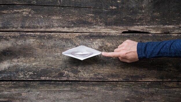 Empurrando o papel para a frente feito barco de origami