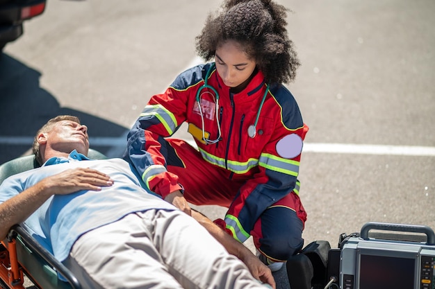 EMT schnallt den Patienten auf der Trage fest