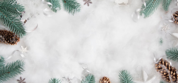 Encabezado de invierno laicos plana: ramitas de abeto en la nieve con decoración navideña con espacio de copia