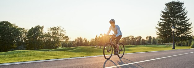 Encabezado del sitio web de vista trasera del hombre atlético en ropa deportiva de pie con bicicleta en el