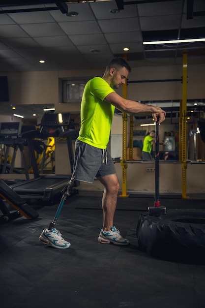 Encajar. Hombre discapacitado entrenando en el gimnasio del centro de rehabilitación, practicando. Hombre activo con discapacidad. Concepto de estilo de vida saludable y activo, motivación, concentración, inclusión y diversidad.