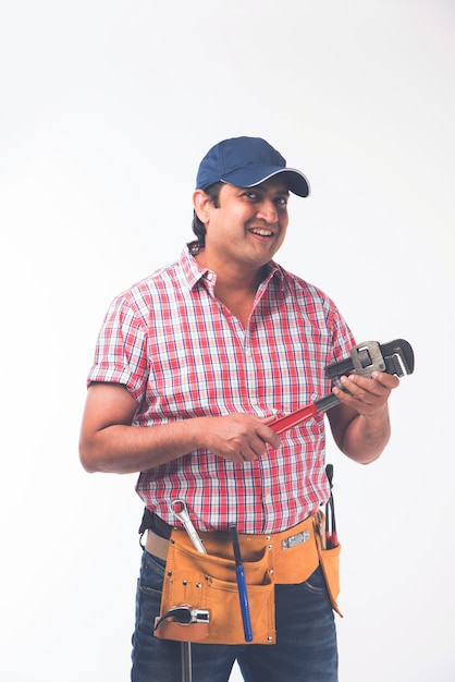 Foto encanador indiano segurando o rolo de desenho e a chave inglesa ou chave inglesa ou smartphone, isolado