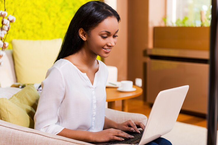 Foto le encanta trabajar en casa. atractivo, joven, mujer africana, trabajando, en, computador portatil, y, sonriente