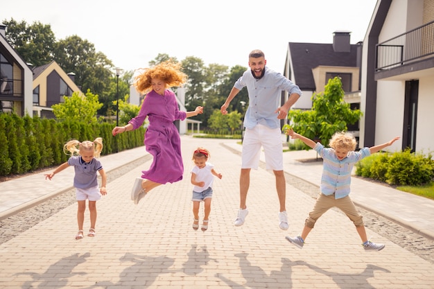 Encantado de familia feliz saltando en la calle