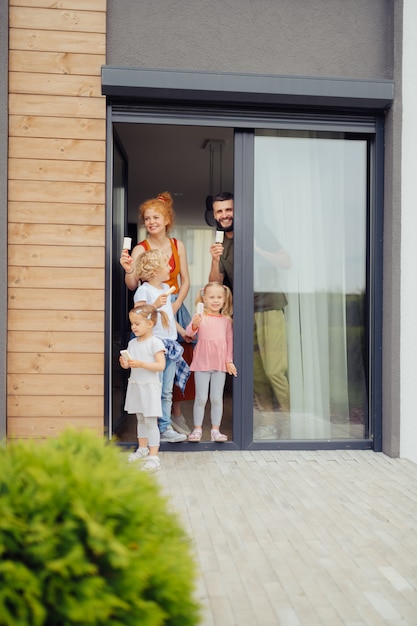 Encantado de familia positiva de pie en la puerta