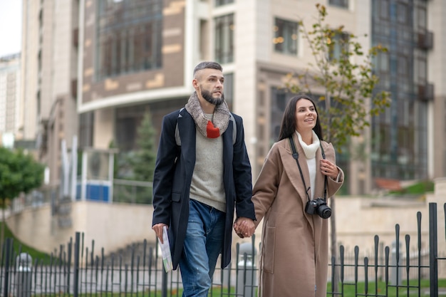 Encantado de joven pareja disfrutando de su tiempo mientras da un gran paseo por el barrio