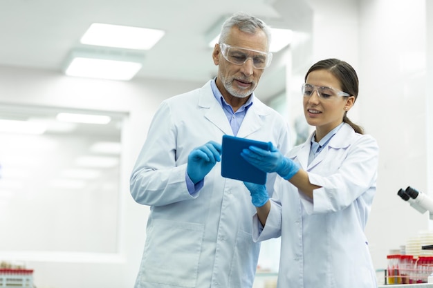 Encantado trabajador médico apoyando a su joven asistente