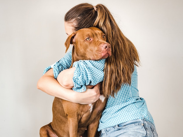 Foto encantador, adorable cachorro de color marrón y una linda mujer.