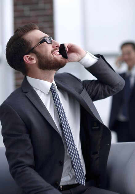 Encantador empresário falando ao telefone em um edifício moderno