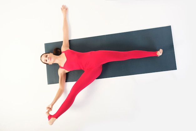 encantador instructor de yoga muestra cómo hacer asanas correctamente