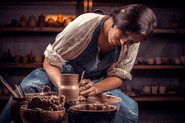 Encantador maestro artesano haciendo cerámica en rueda. El concepto de creatividad artesanal.