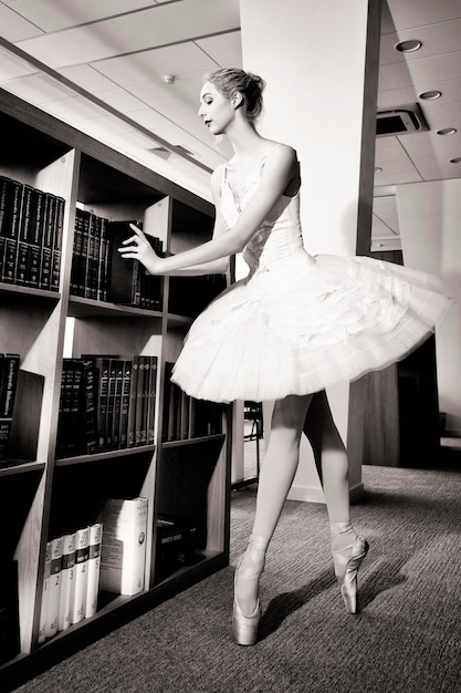 Foto una encantadora bailarina fue a la biblioteca a elegir un nuevo libro durante un descanso