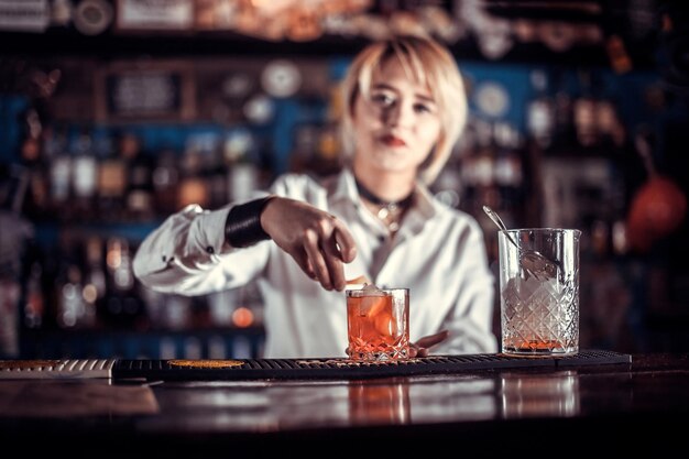 Encantadora chica barman sorprende con su habilidad bar a los visitantes en la discoteca