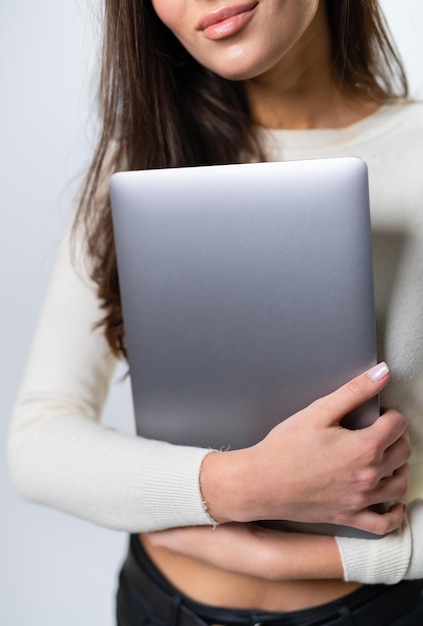 Encantadora dama con portátil gris en las manos Cuaderno de tecnología moderna con hermosa mujer