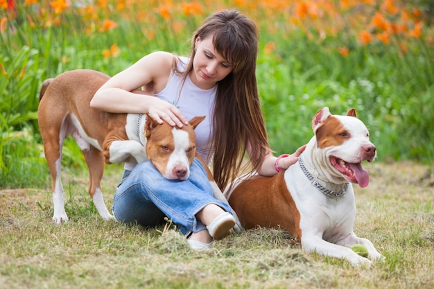 Encantadora dama posando con perros al aire libre