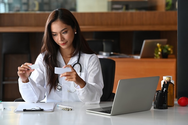 Encantadora doctora en uniforme médico trabajando en clínica médica.