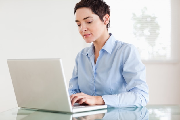 Encantadora empresaria de pelo corto con una computadora portátil