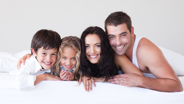 Encantadora familia acostada en su cama