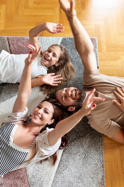 Foto encantadora familia tendida en el piso