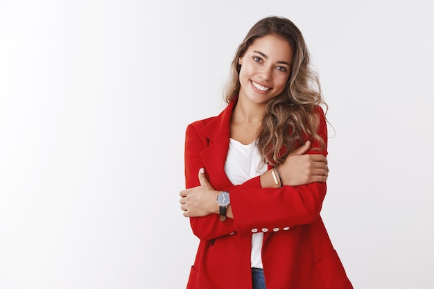 Foto encantadora feminina feliz jovem empreendedora de sucesso abraçando, braços cruzados no peito inclinando a cabeça fofa, sorridente, terna, empresária gerenciando combinar os deveres familiares e os negócios