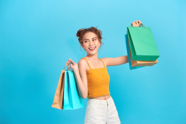 Encantadora hermosa mujer asiática confía en mostrar bolsas de compras.