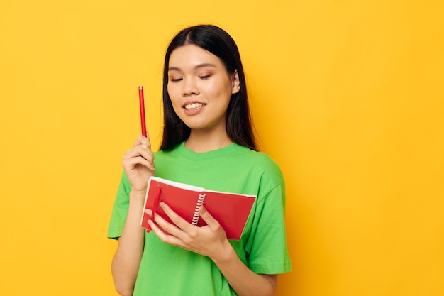 Encantadora jovem asiática, notebook e caneta, aprendendo o modelo de estúdio de educação inalterado