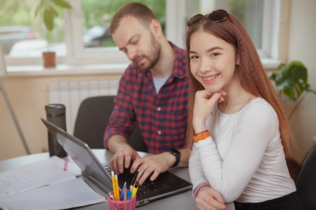 Encantadora joven adolescente trabajando en un proyecto con su maestra