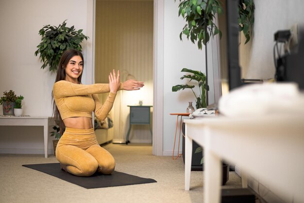 Foto encantadora joven atleta estirando sus brazos antes de hacer ejercicio