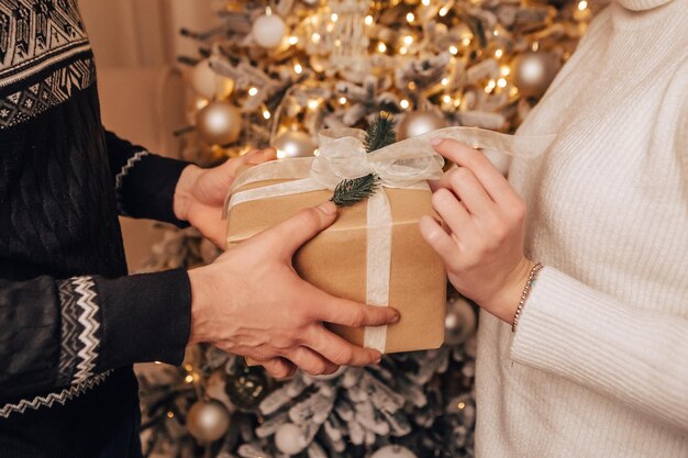 Encantadora joven pareja romántica sentada regalos abiertos presenta guirnaldas hogar acogedor ambiente interior